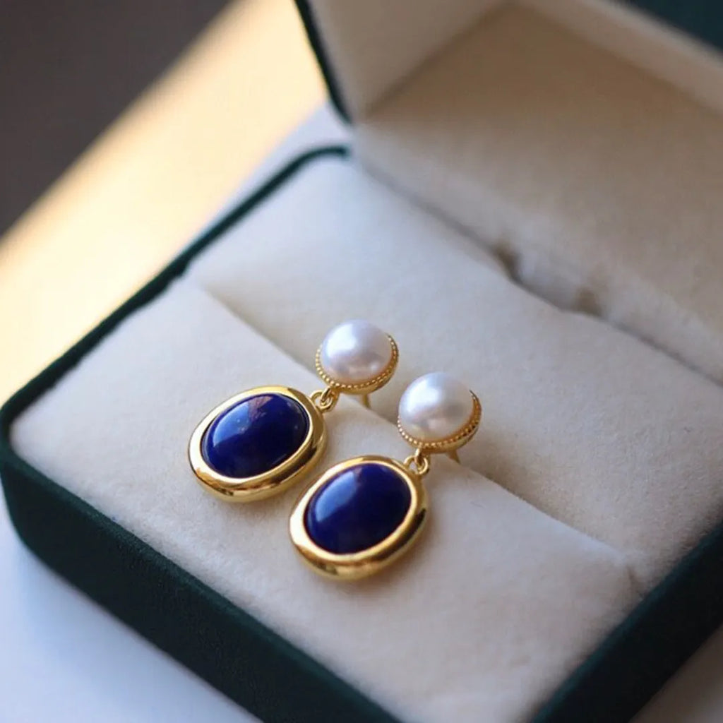 A pair of simple stud earrings with blue lapis lazuli pearls set in silver backs.
