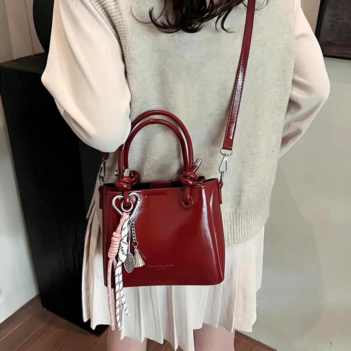 Women's PU one-shoulder bucket messenger bag in black with pendant, showing front view with single strap