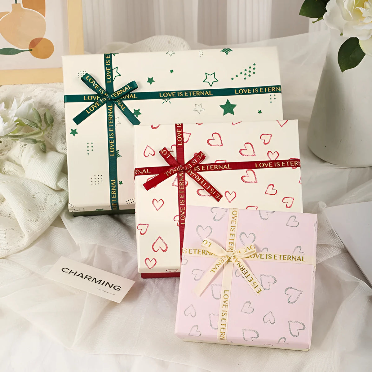 Cardboard gift box with bow in red, green, and pink, multiple sizes for gifts