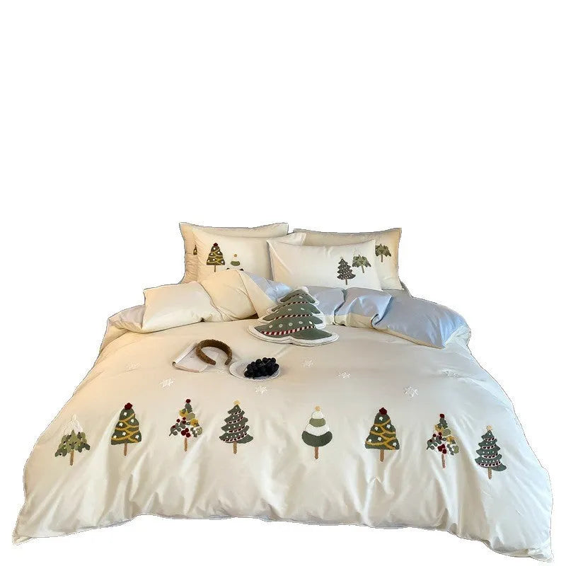 Cream blue cotton duvet cover with embroidered Christmas tree and floral design, laid on a bed with matching pillowcases.
