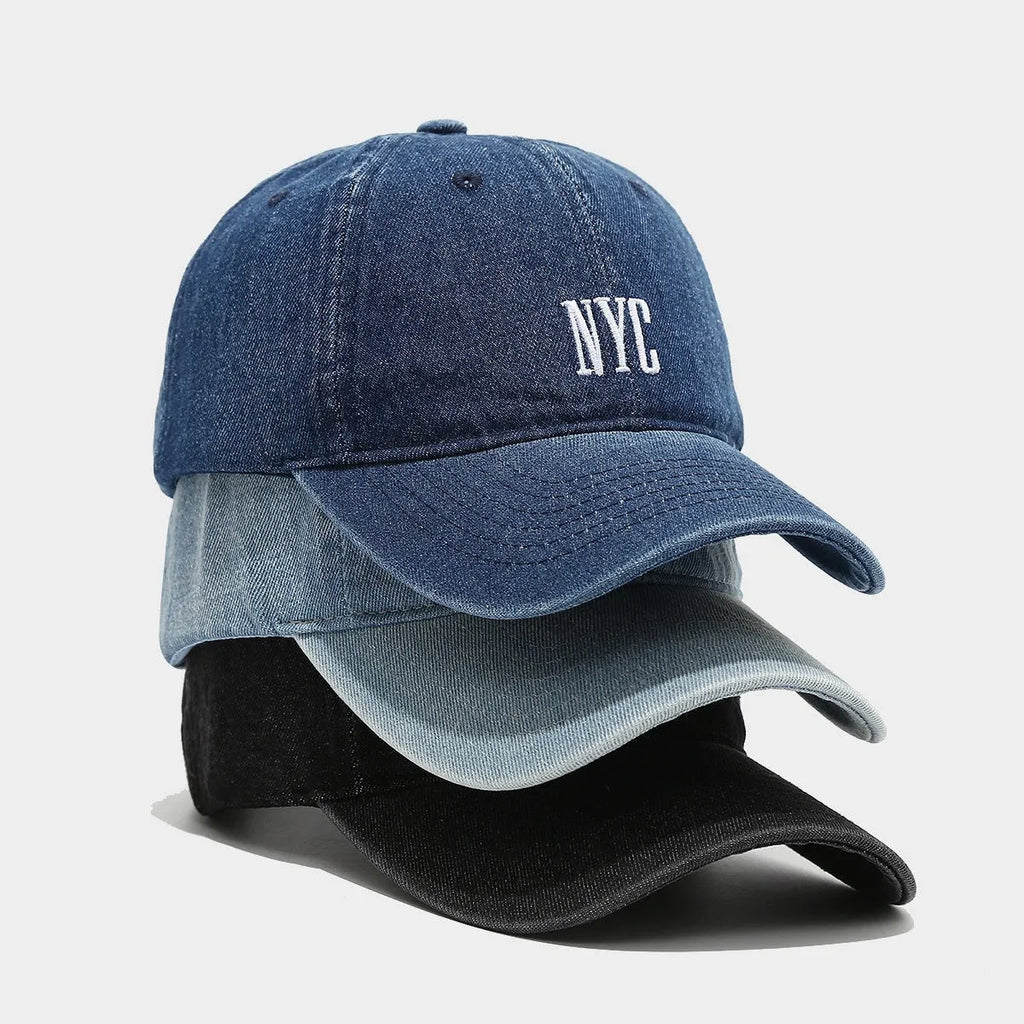 Adjustable denim peaked cap with a dome crown and a large English letter design on the front.