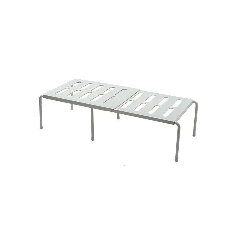 White telescopic plastic storage rack extended to full height with kitchen utensils organised on shelf