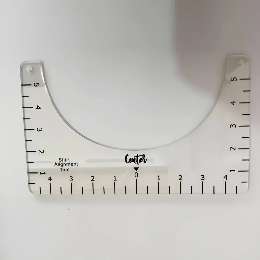 Transparent acrylic sewing ruler for T-shirt alignment and patch placement on fabric.