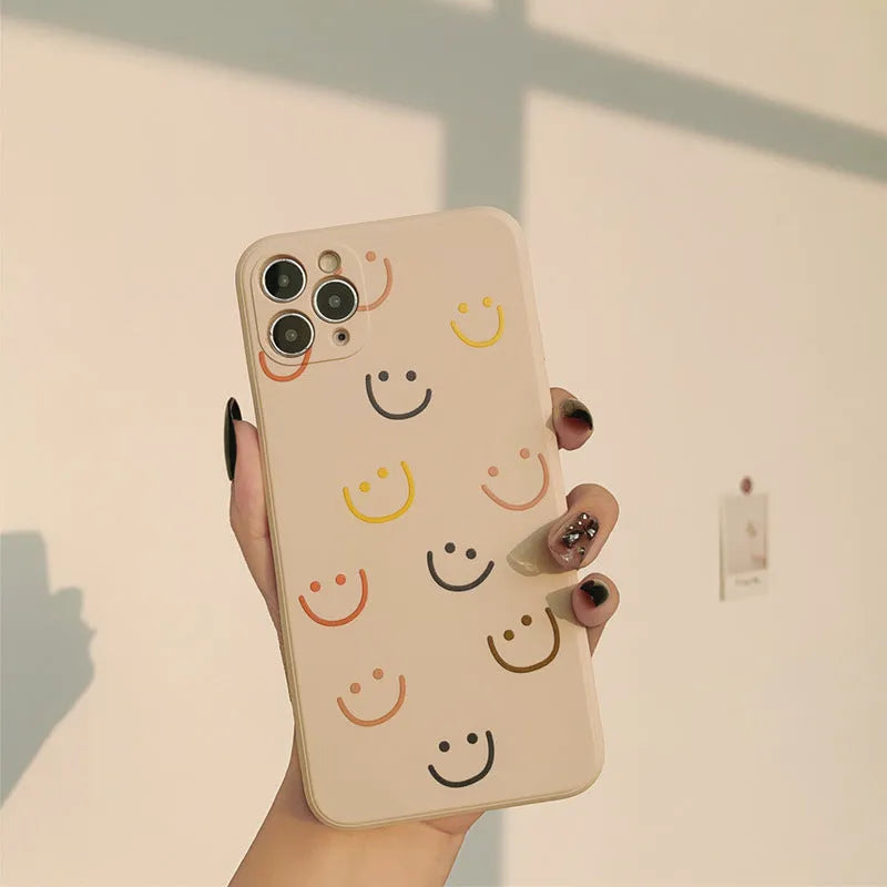 Painted silicone iPhone case showing smiley, rainbow, and watercolour design options