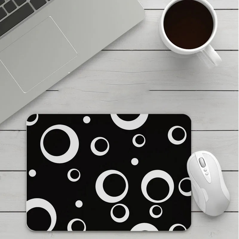 Thick custom cartoon mouse pad with colourful design on a desk, showing black seam edge