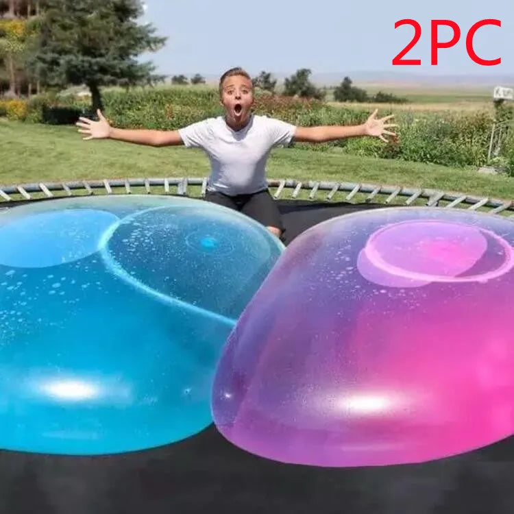 Assortment of inflated pink, yellow, blue and green TPR bouncy balls in different sizes on a plain background.