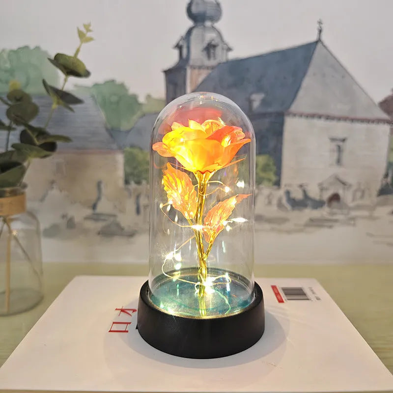 Small decorative night lamp with plastic flowers and a glass-style cover on a black base.