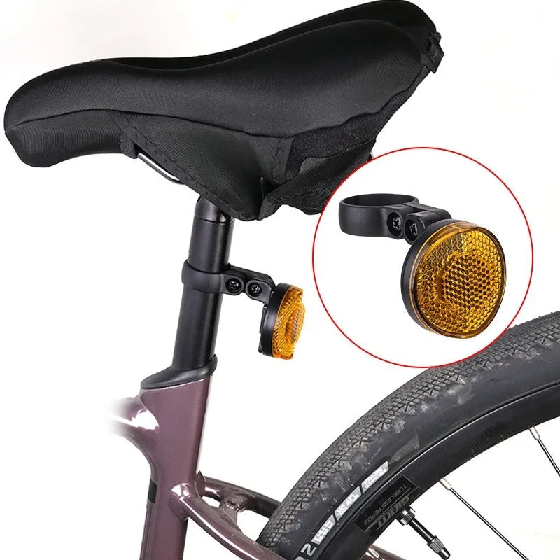 Red plastic anti-theft bicycle taillight bracket with integrated reflector mounted on a seat post.