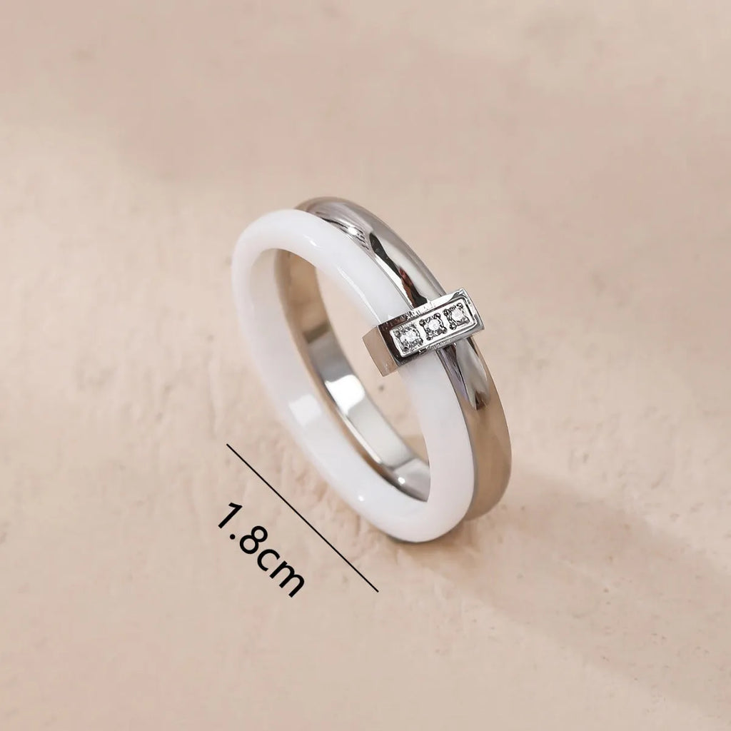 A glossy titanium steel women's double ring with a heart-shaped zirconium inlay, shown in steel white colour.