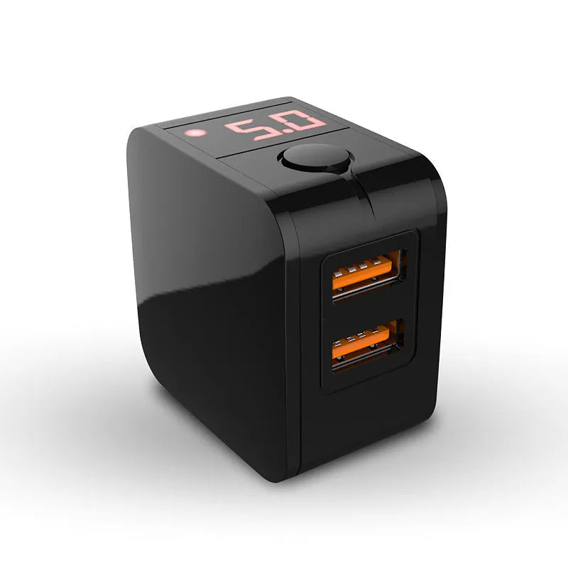 A black dual USB travel charger with a digital display showing '5V', plugged into a UK wall socket.