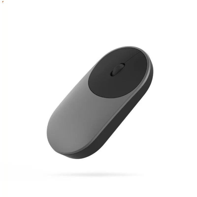 Black wireless Bluetooth mouse beside laptop showing compact design