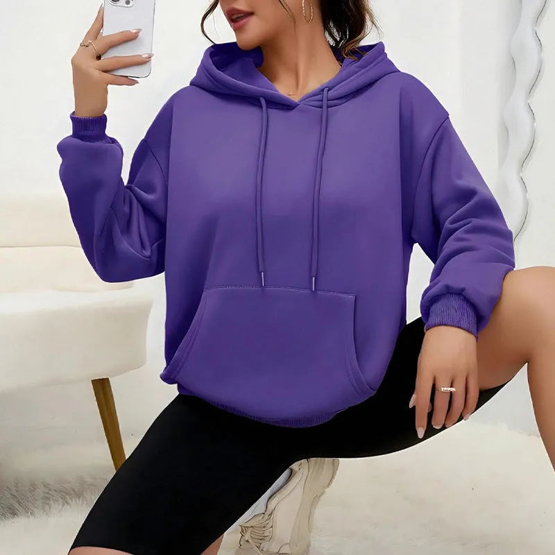 Women's loose grey drawstring hoodie with front kangaroo pockets, on a hanger.
