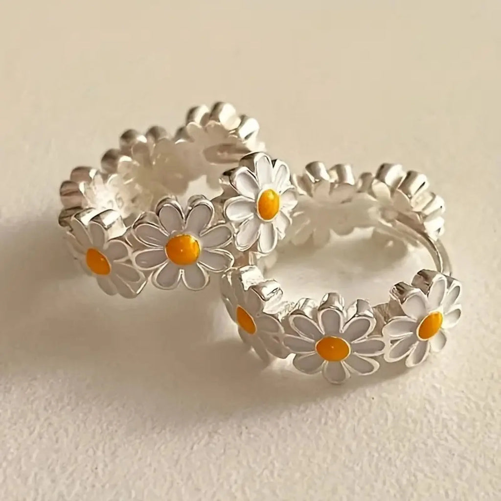 White electroplated copper daisy flower earrings with platinum gem inlay on white background