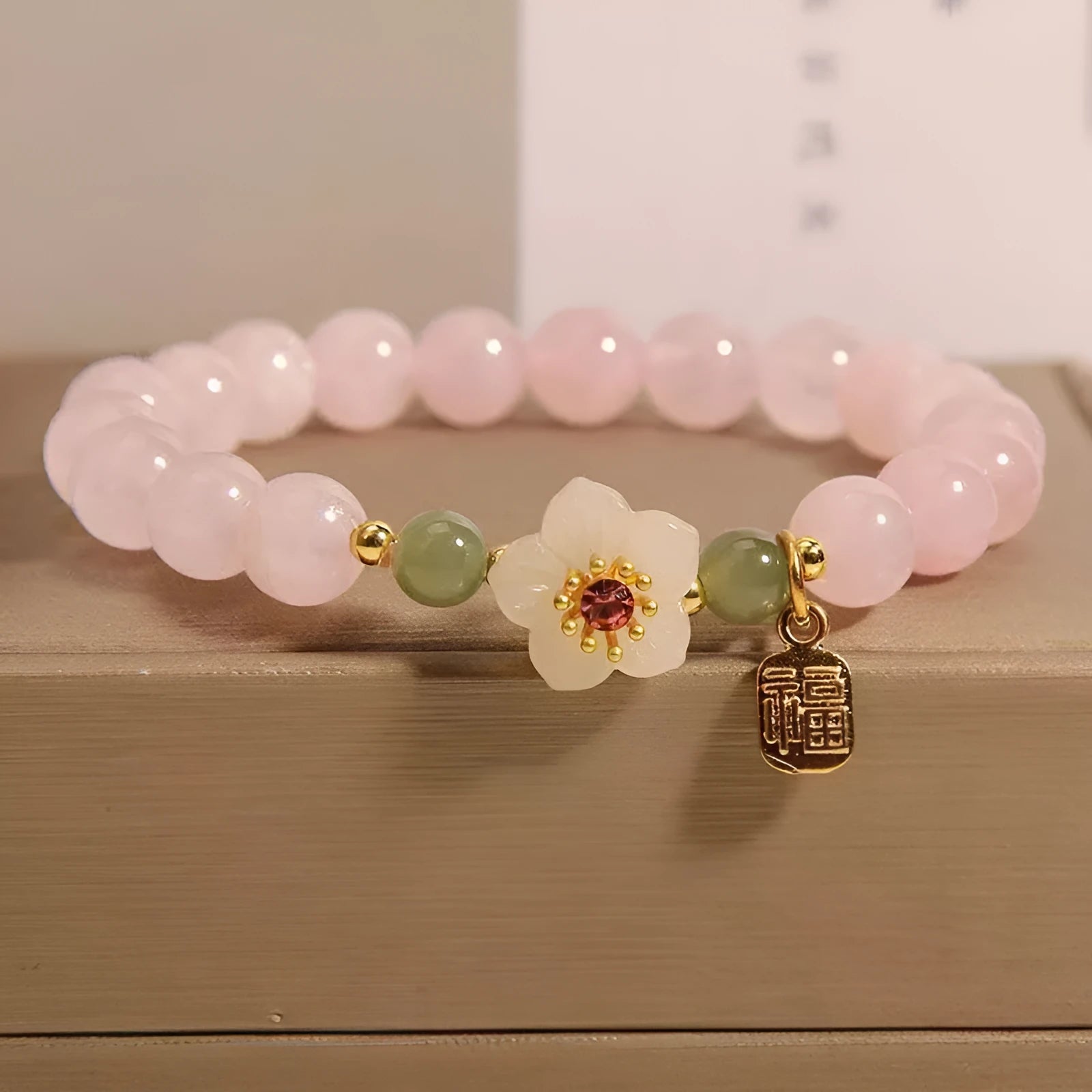 Crystal bracelet with Hetian jade beads showing peach blossom design, fruit charm, and camellia elements