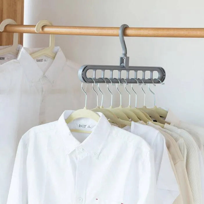 Plastic clothes hanger with rotating hook in pink colour, shown next to a green hanger.
