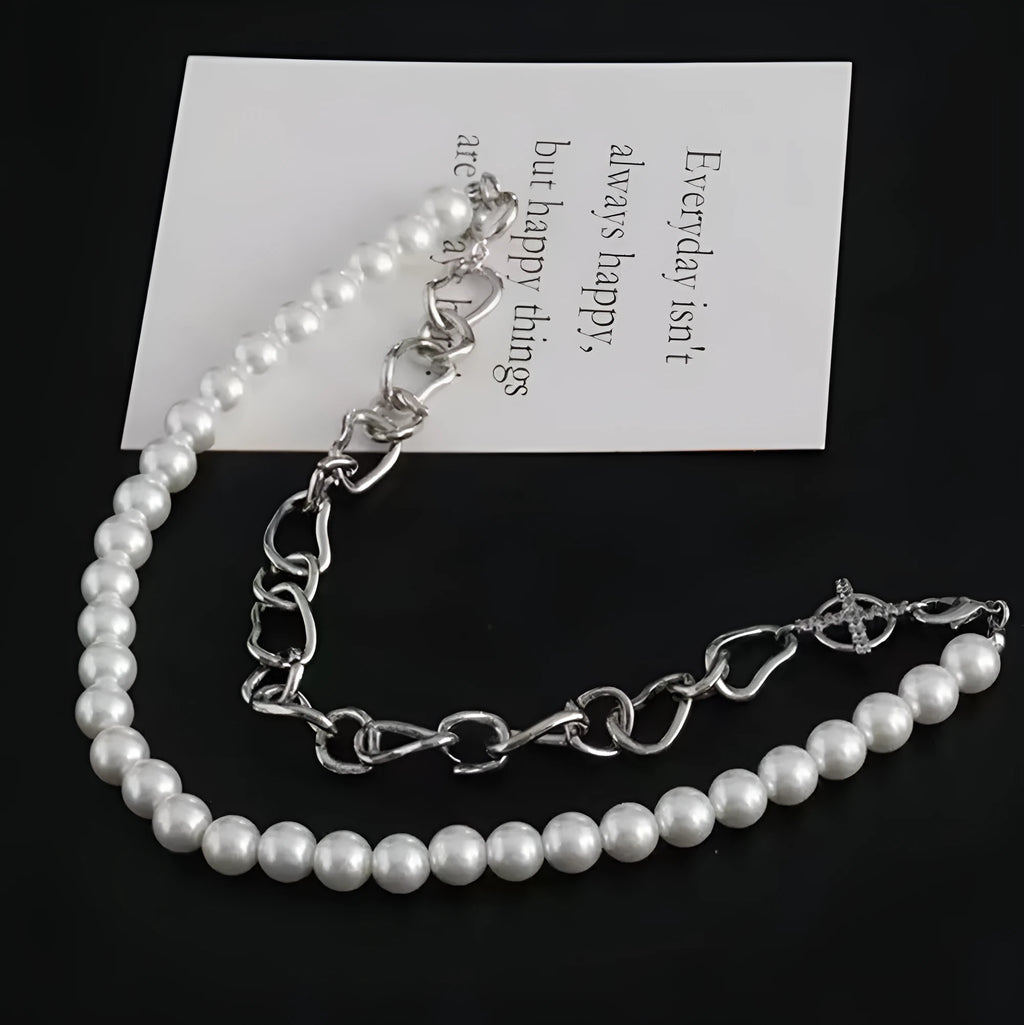 White geometric asymmetric acrylic pendant necklace on a twisted metal chain, shown against a neutral background.