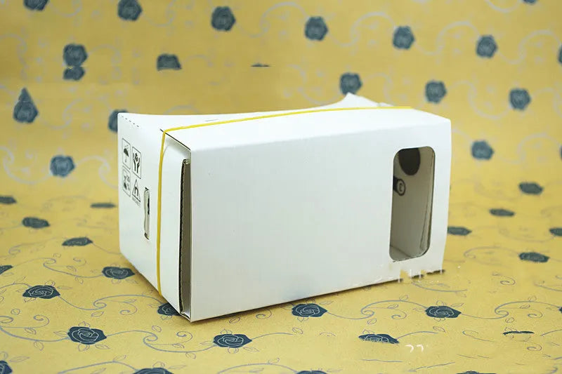 Pink and white flat-pack cardboard VR glasses viewer for smartphones with 3D lenses and straps.