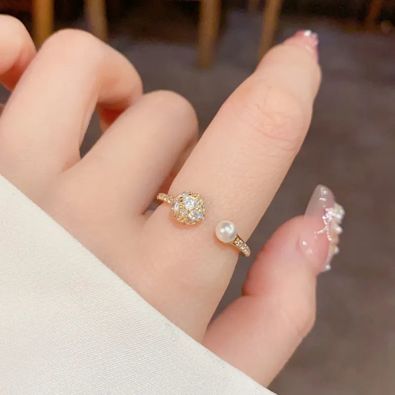 Golden open-end ring with round zircon stone on a white background.