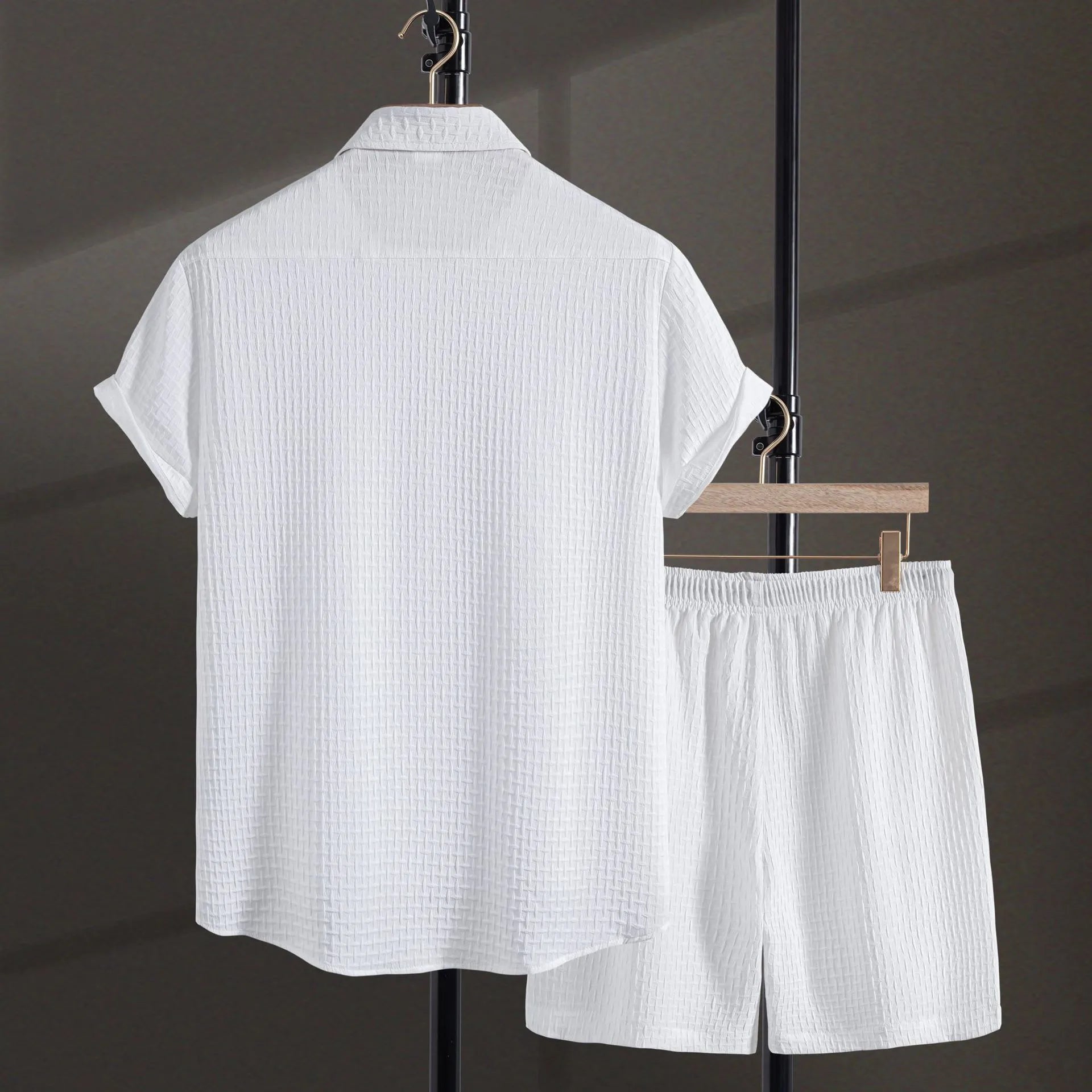 Men's white cotton blend beach suit with short sleeve shirt and loose-fitting shorts on a hanger.