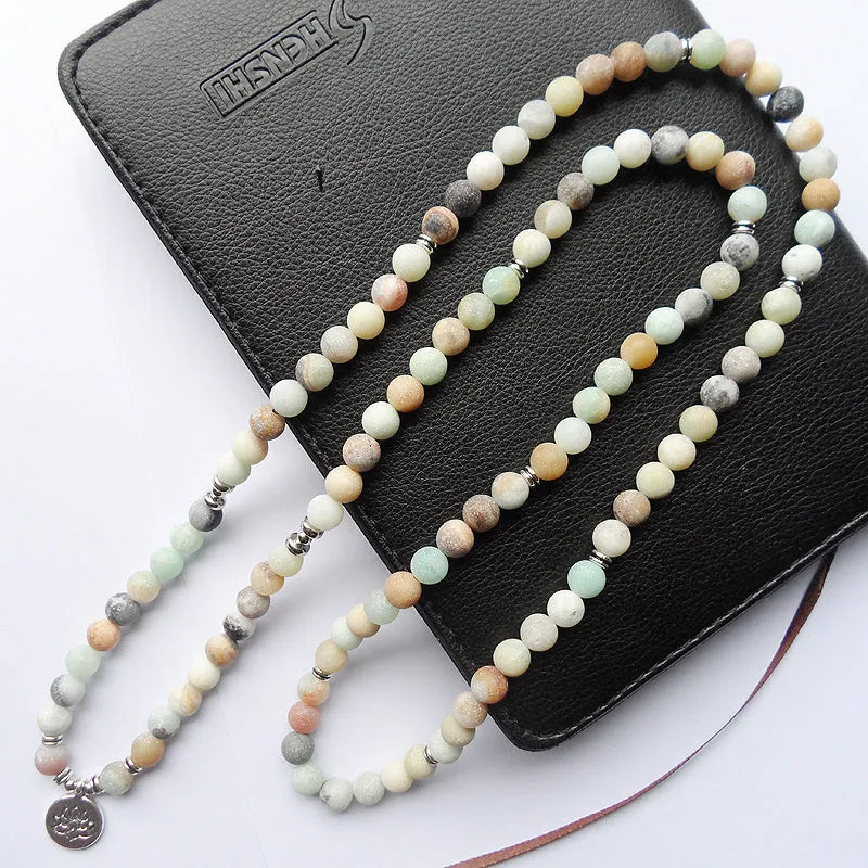108 bead matte amazonite mala bracelet with lotus Buddha pendant on a surface