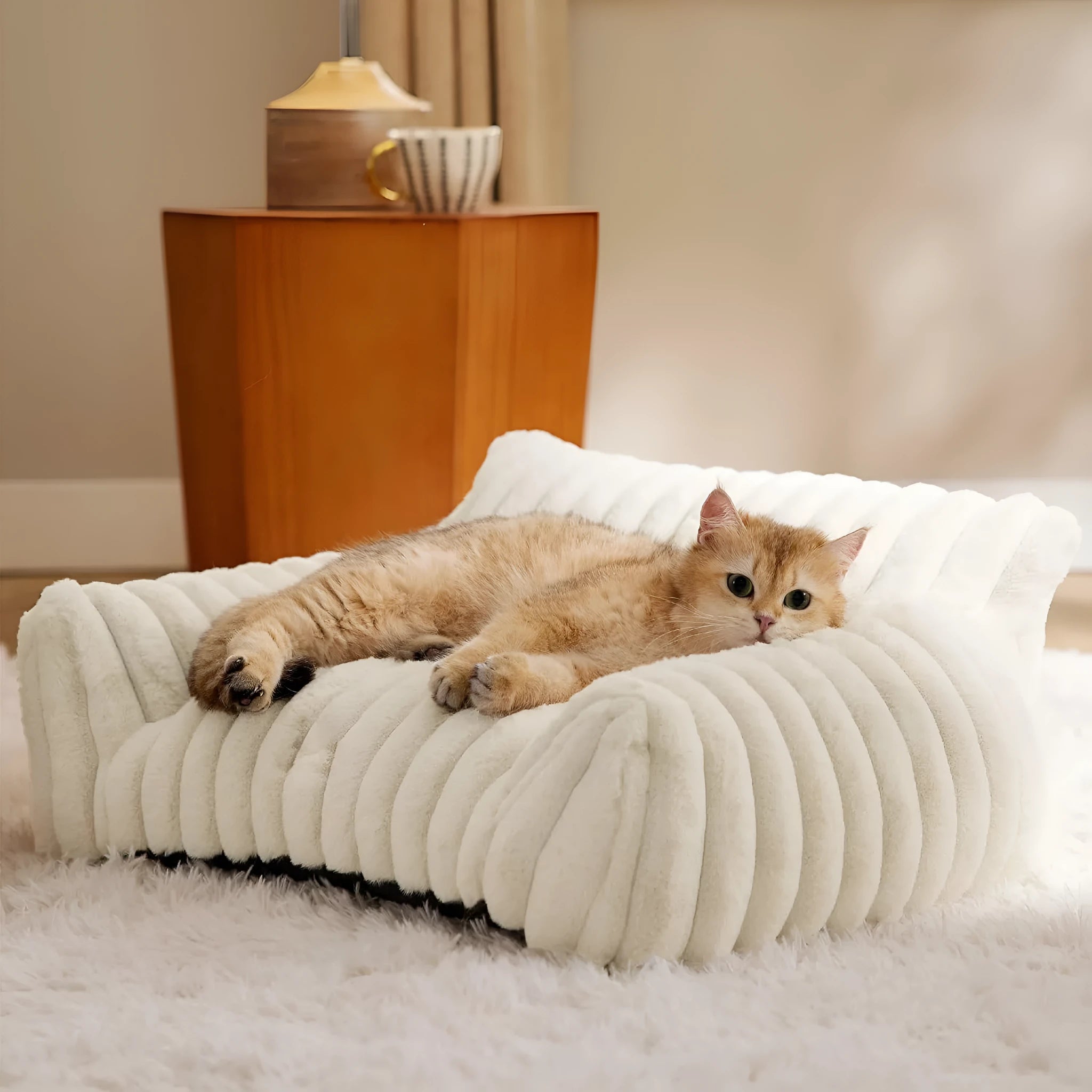 Beige corduroy cat couch with high backrest for pet support on a wooden floor.