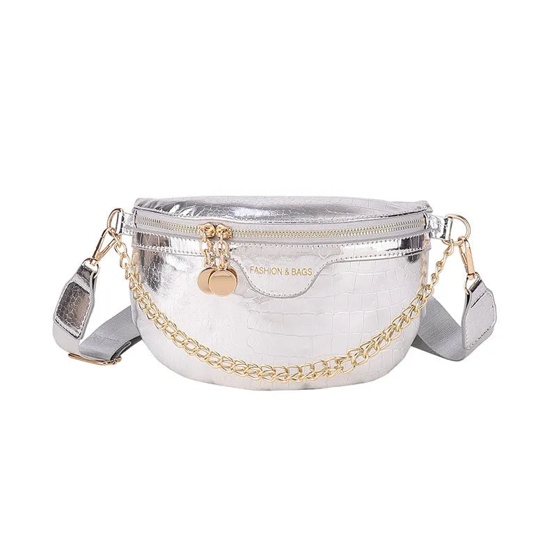 Shiny hard-shell PU chest bag with wide shoulder strap, chain detail, and internal pockets in silver colour