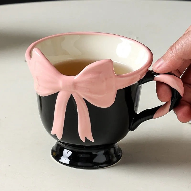 Ceramic mug with heart bow design in black pink and white powder colour options