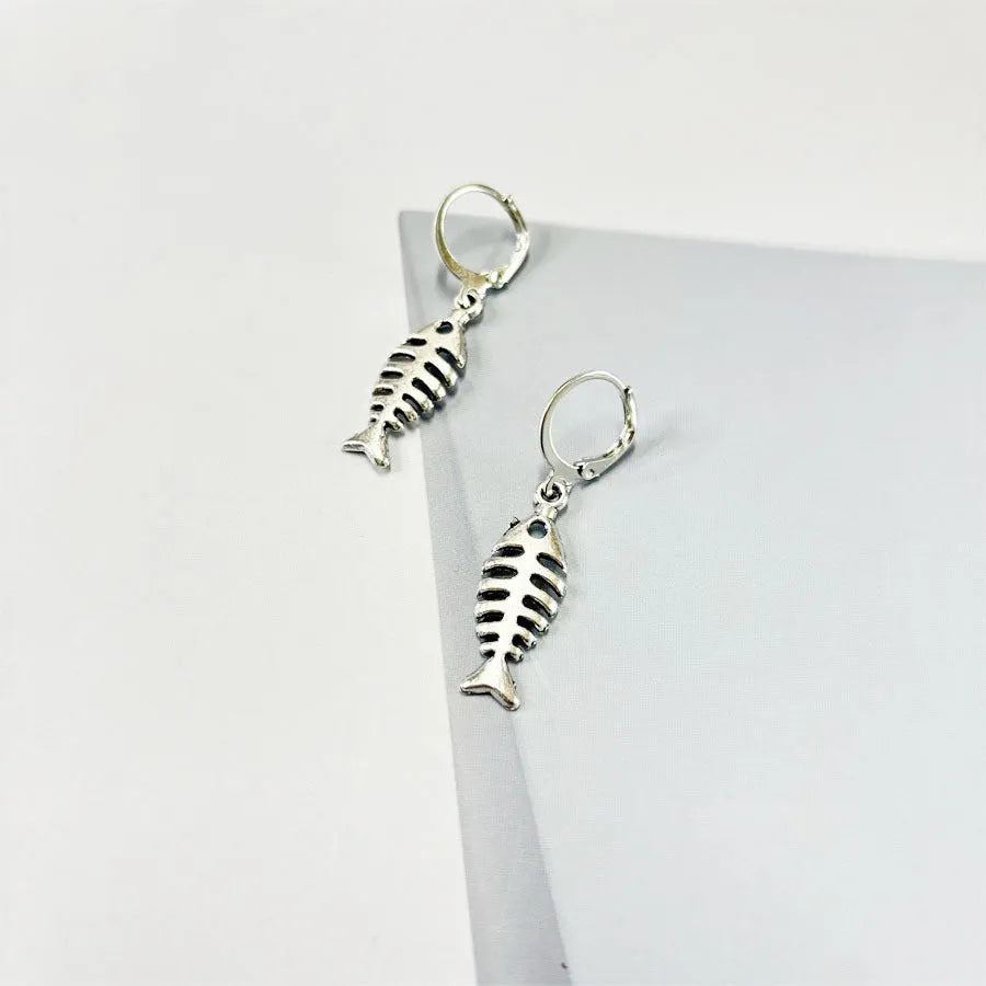 Fishbone pendant necklace and matching earrings set with adjustable chain on retro background