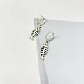 Fishbone pendant necklace and matching earrings set with adjustable chain on retro background