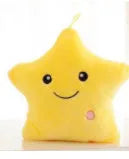 Colourful glowing five-pointed star plush pillow on a dark background, showing soft texture and LED illumination