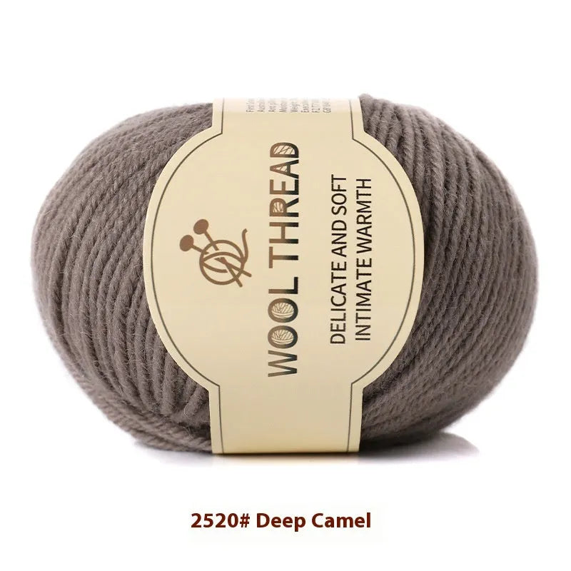 One roll of beige domestic wool hand-knitting yarn for size 10 needles next to knitting needles.