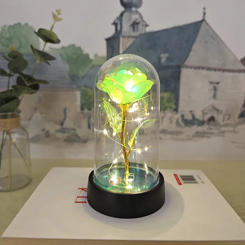 Small decorative night lamp with plastic flowers and a glass-style cover on a black base.