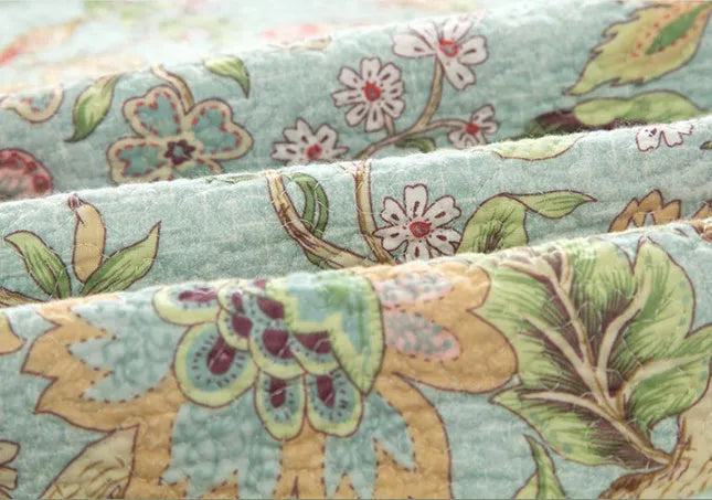 Blue American floral and bird pattern quilted cotton bedspread set on a bed, showing detailed stitching and 230x250cm size.