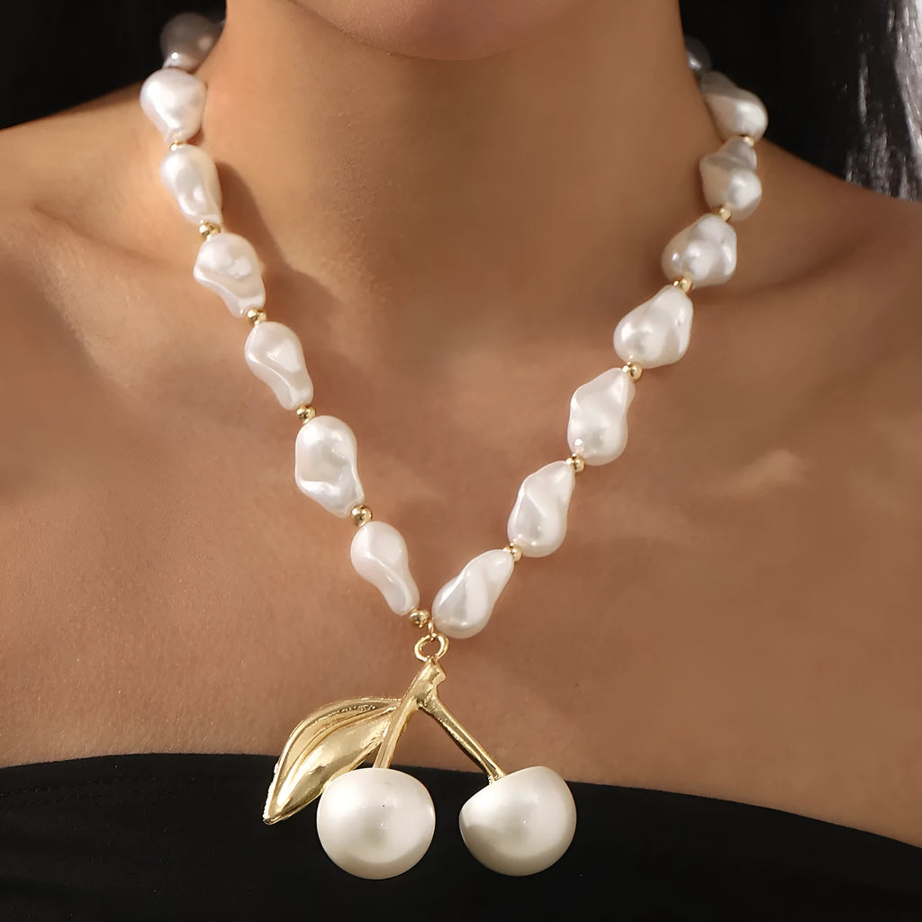 Gold irregular geometric cherry fruit pendant on an adjustable pearl chain necklace for women.