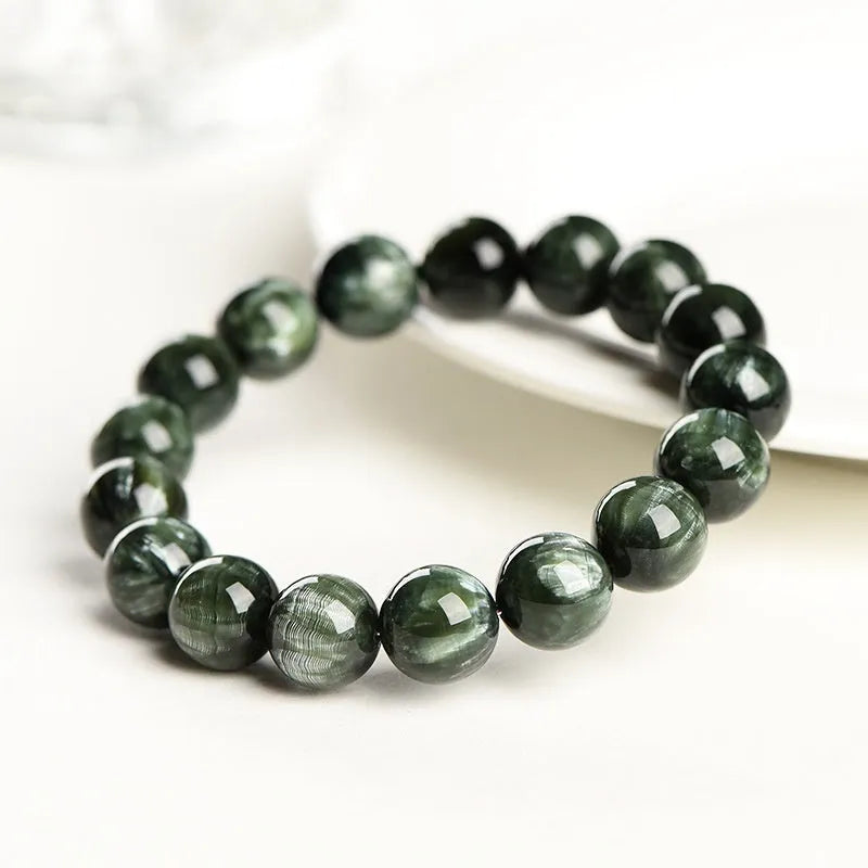 Natural green dragon crystal bead bracelet with geometric ruyi pattern on white background.