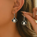 Pair of silver colour retro creative drop dangle earrings for women on a white background.
