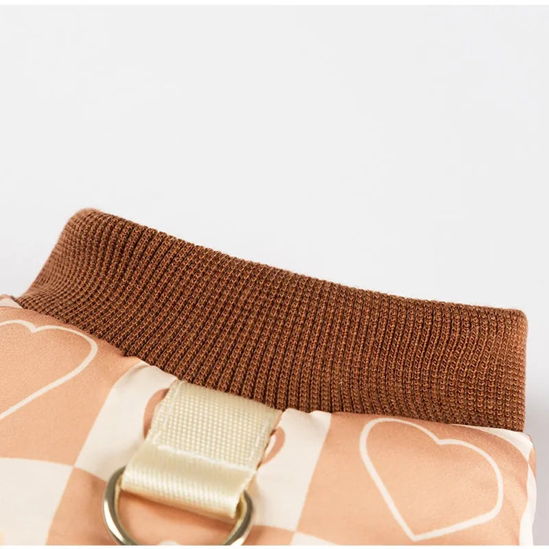 Quilted two-legged pet vest with leash ring in brown bear print or geometric red-green, sizes XS-XXL.