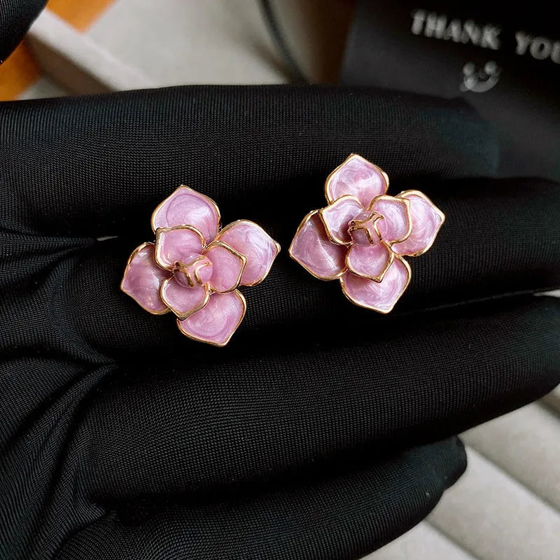 Gold plated stud earrings with a purple oil-spot glaze flower design on a copper base.