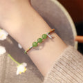 Hetian jade diamond-shaped bracelet with lotus seedpod design and woven carrying strap in light green or haze blue colour options
