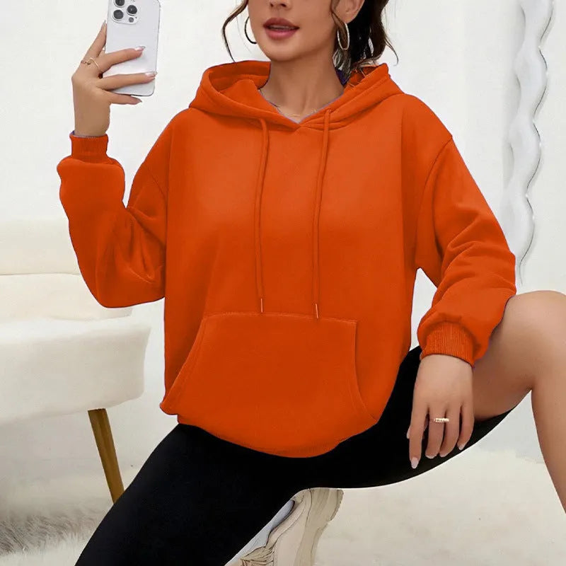 Women's loose grey drawstring hoodie with front kangaroo pockets, on a hanger.