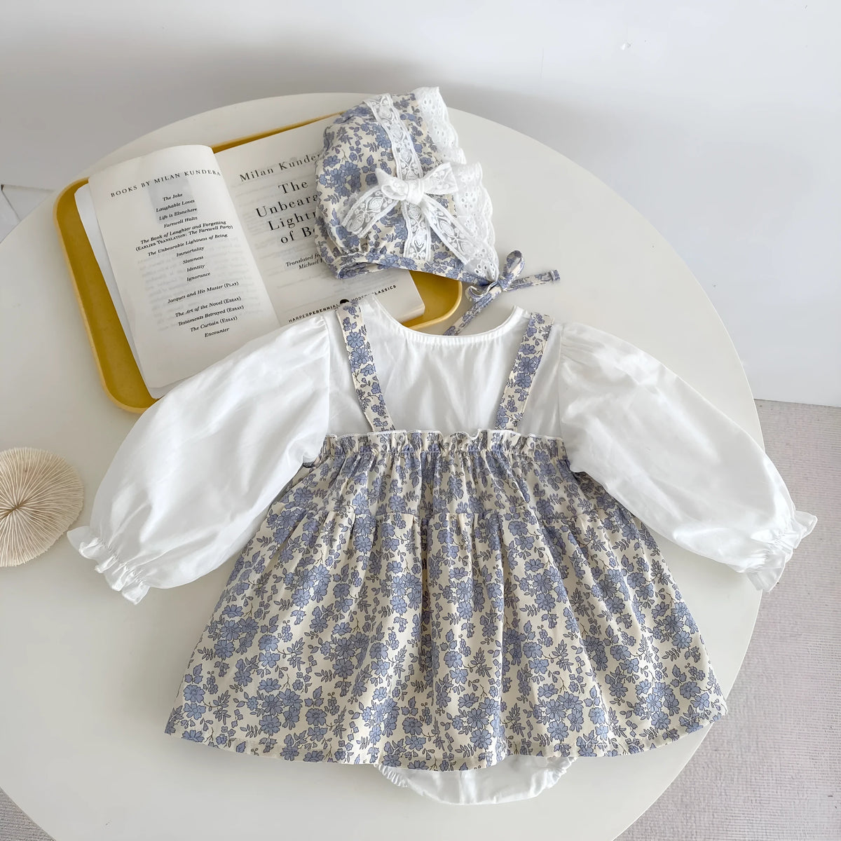 White cotton baby girls' floral princess romper with long sleeves, pullover closure, and removable hood in triangle jumpsuit style