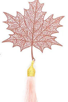 Detailed brass bookmark with hollow maple leaf pendant and rose gold tassel on a book page.