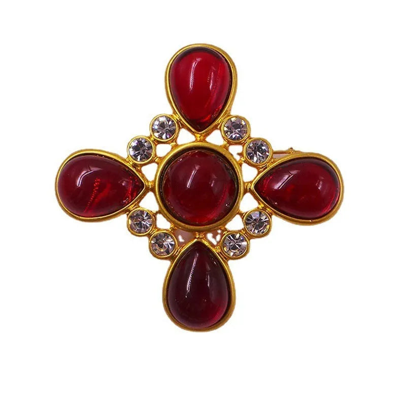 Close-up of vintage medieval baroque cross brooch with crystal accents on zinc alloy.
