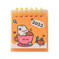 Mini desk calendar with cartoon design showing 9.3cm x 6.4cm paper calendar on a table
