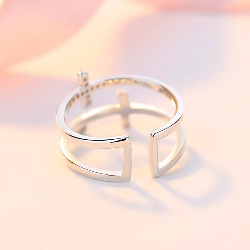 Women's adjustable copper ring with double cross design and white zircon stone in sterling silver inlay.
