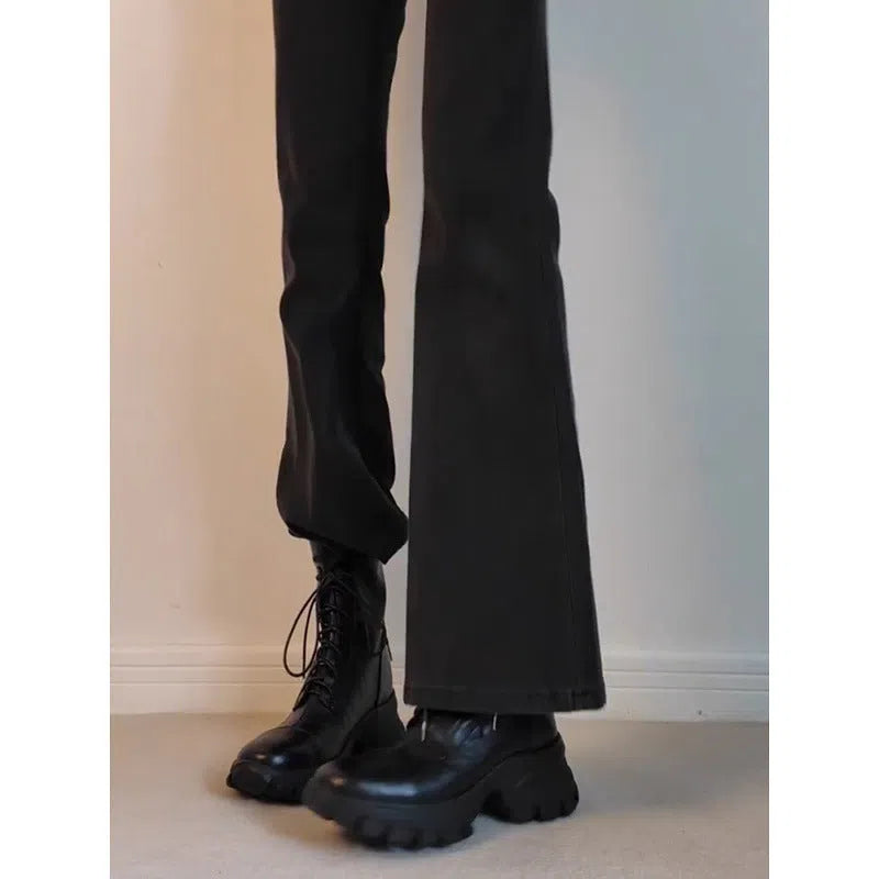 Black thick-soled motorcycle boots with back zipper, lace-up front, round toe, and rubber sole on a neutral background