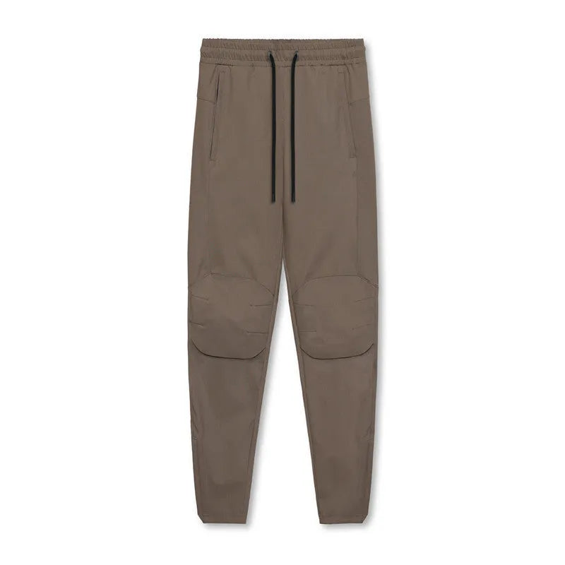 Man wearing dark grey loose-fit ankle-tied fitness trousers made of quick-drying polyester during a workout.