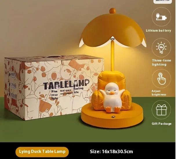 Cute yellow duck plastic night light table lamp with USB cable and gift box on a modern desk