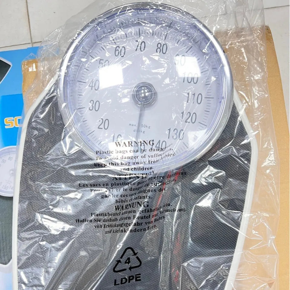 Black mechanical body weight scale with large dial and pointer on a simple platform