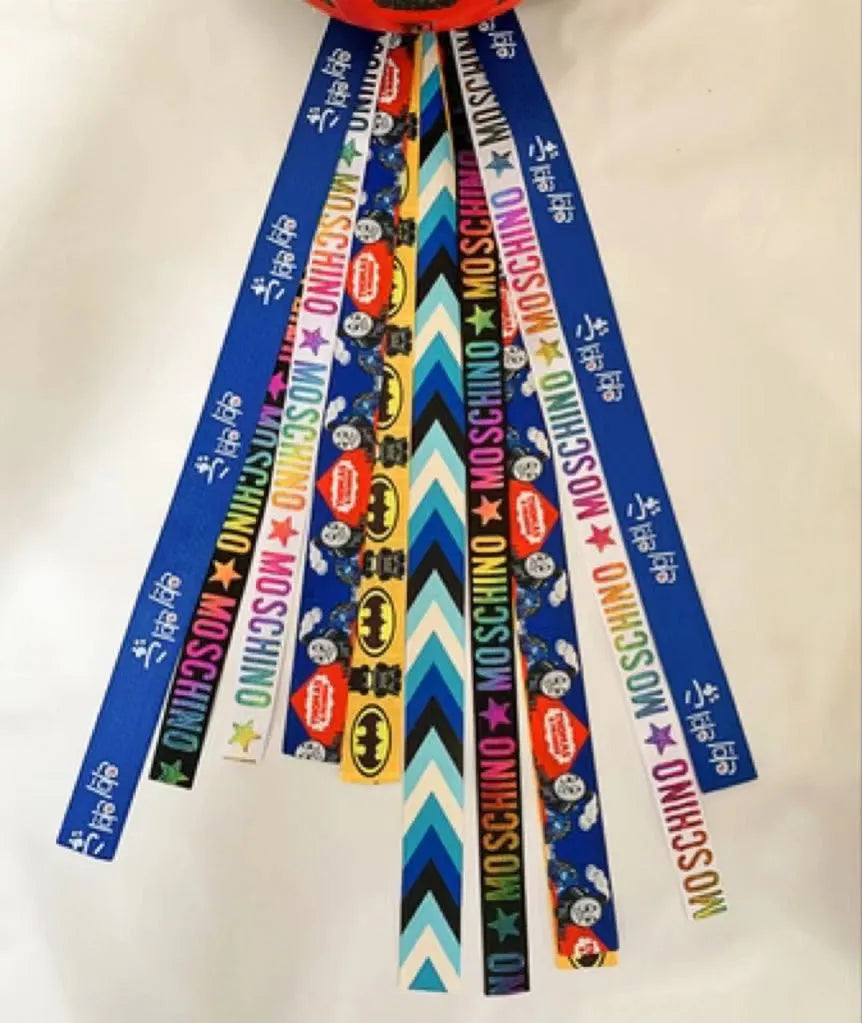 A decorative ribbon streamer for attaching to a child's roller skate or ski helmet, shown in a selection of colours.